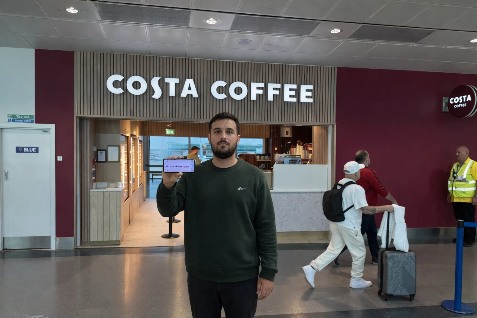 driver with name board at Stansted Airport terminal